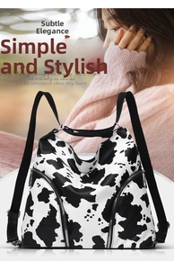 Detailed macro view of the fashion animal print backpack with smooth cow pattern and silver zippers