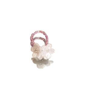 Pink and white handmade resin flower beaded ring displayed on a white reflective surface