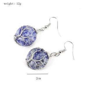 Detailed view of handmade tree of life earrings with blue natural stone and silver wire