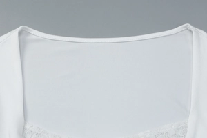 Close-up of elegant white lace splicing and fine stitching on the square neckline