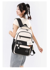 Girl wearing a lightweight waterproof school backpack with a cloud pendant on her back