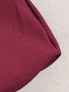 Macro shot of burgundy ribbed elastic fabric detail with high-quality stitched edges