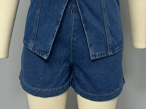 Détail d'un ensemble en jean bleu foncé avec short taille haute et coutures sur mannequin