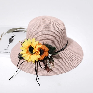 Detail of pink woven sun hat with decorative sunflowers and textured straw craftsmanship