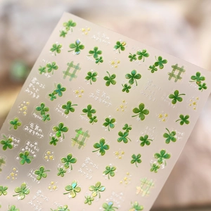 Macro shot of 3D lucky green clover nail stickers with fine adhesive texture details