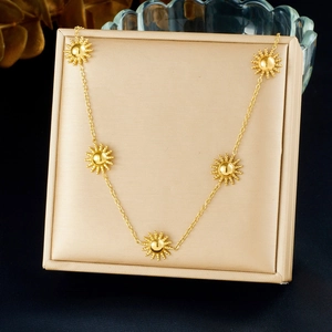 Polished gold-plated stainless steel sun pendant necklace set in a beige jewelry gift box