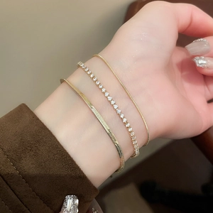 Three-piece gold-toned bracelet set featuring herringbone chain and zircon tennis styles