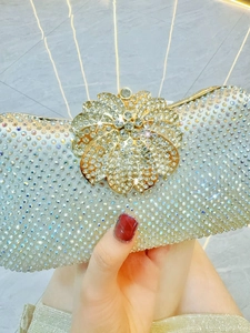 Nahaufnahme der glitzernden Abendtasche mit einem detaillierten goldenen Blumenverschluss