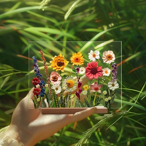 Detail of colorful floral acrylic display piece with wooden base held against nature