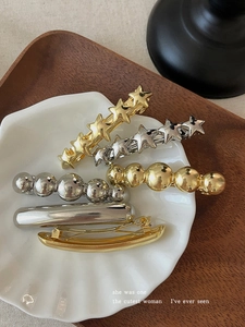 Detailed set of gold and silver metallic spring hair clips with star and bead designs