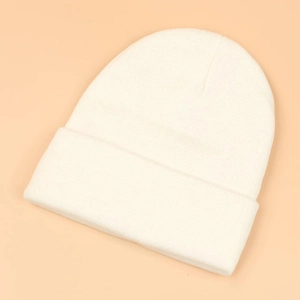 Close-up of a white winter beanie with detailed knit texture and a wide folded cuff