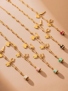 Detail of gold beaded necklaces with colorful enamel charms like hearts and clover