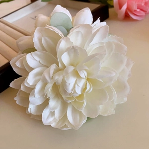Macro shot of detailed large white fabric rose hair claw with layered petals on wood