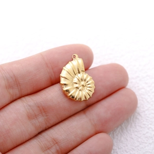 Close-up of a 18K gold-plated conch shell pendant held between fingers for size detail
