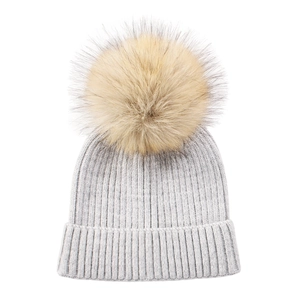 Detailed close-up of light grey ribbed knit texture and fluffy faux fur pompom detail