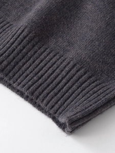 Macro shot of dark grey ribbed knit texture and soft fabric fibers on the sleeve cuff
