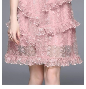 Close-up of pink luxury lace embroidery and ruffled layers on a short princess dress