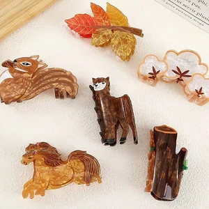 Cute animal acetate hair claws featuring alpaca squirrel and leaf designs on beige surface