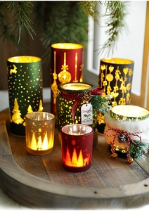 Close-up of elegant Christmas glass candle holders with reindeer patterns and warm LED lights