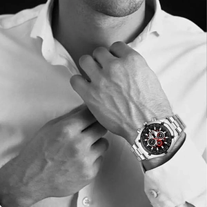Men's silver steel sports watch with black dial and red accents on a male wrist