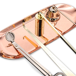 Polished stainless steel candle care set with trimmer and snuffer on a rose gold tray
