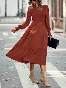 Détail de la robe mi-longue rouge brique à buste froncé et jupe à volants étagés