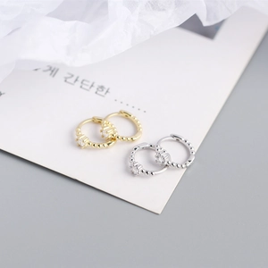 Detailed view of gold and silver S925 sterling silver hoop earrings with round zircons