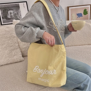 Dettaglio della borsa tote in nylon giallo chiaro con stampa Bonjour magic in stile lifestyle