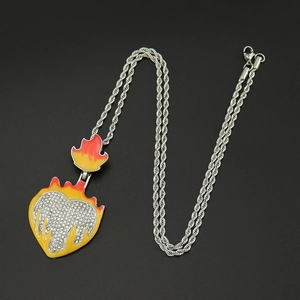 Macro shot of hip hop heart pendant with yellow glaze, rhinestones and fire patterns