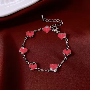 Vintage silver chain bracelet with seven textured red heart charms and adjustable clasp
