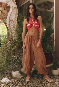 Detailed texture of brown striped wide-leg pleated trousers with breathable fabric for women