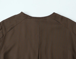 Détail de l'encolure et de la couture d'épaule sur robe marron à pois avec texture de tissu