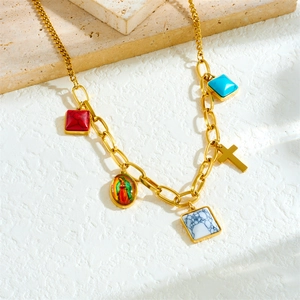 French vintage gold necklace with colorful gemstone pendants and religious charms on stone