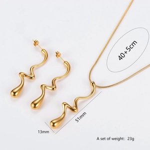 Elegant gold wave-shaped jewelry set with long earrings and pendant necklace on white