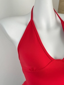 Macro detail of red halter neck top showing high-quality fine knitted texture