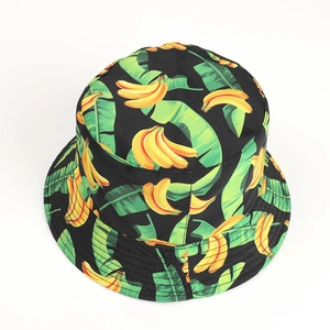Detailed close-up of tropical banana and green leaf print on black cotton bucket hat fabric