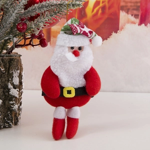 Detalle de Papá Noel de peluche con terciopelo rojo y adorno festivo de pino navideño