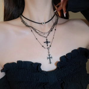 Dettaglio della collana punk con ciondoli a croce in argento e strass su cinturino in pelle