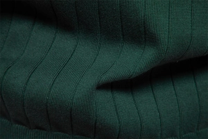 Dettaglio della trama a coste verticali su un morbido cardigan verde scuro
