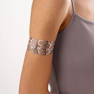 Dettaglio di un bracciale da braccio in argento traforato con intricati motivi floreali