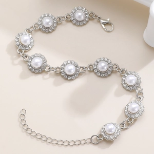 Dettaglio del bracciale a fiori argentati con perle bianche e strass scintillanti