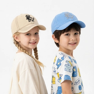 Detail shot of young boy and girl wearing dinosaur embroidered cotton baseball caps