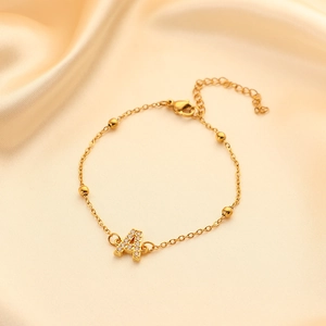 Detail of gold-plated stainless steel letter A bracelet with pavé rhinestones and beads