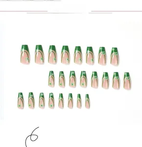 Detail view of floral French press-on nails with green edges and coffin shape design