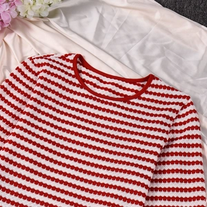 Vue détaillée d'une robe en maille rayée rouge et blanc avec texture douce et col rond