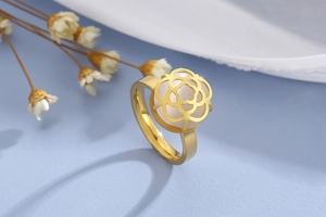 Detail view of golden stainless steel ring featuring a white camellia flower ornament