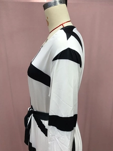 Detail of black and white striped long sleeve dress with waist tie on a mannequin