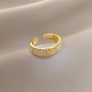 Nahaufnahme des vergoldeten Kleeblatt-Sternrings mit Kristallen auf Samtstoff