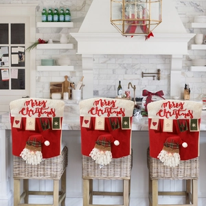 Trois housses de chaise de Noël avec motif Père Noël et texte festif dans une cuisine