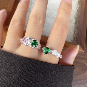 Detail of 925 silver rings featuring irregular lava texture and emerald green gemstones